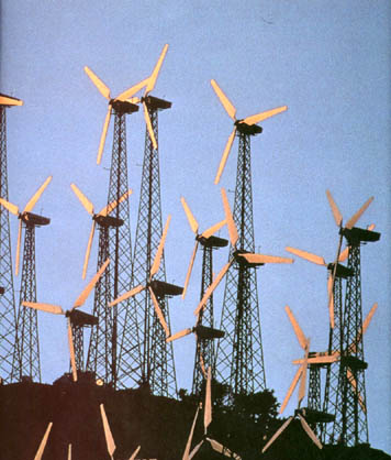 Windmills on hillside at sunset
